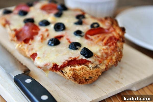 Elevated French Bread Pizza 4 A pepperoni and olive-topped french bread pizza on a cutting board.