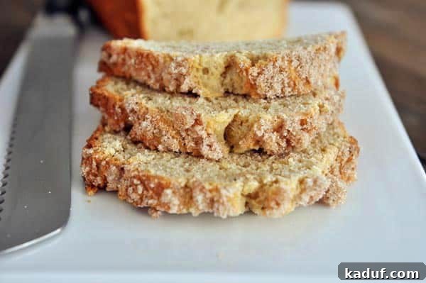 Cream Cheese Swirl Banana Bread with Cinnamon Crumble 12 Three golden-brown slices of streusel-topped banana bread, stacked elegantly on top of each other on a pristine white platter, showcasing their tempting texture and delicious topping.