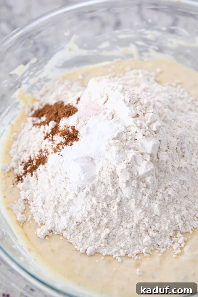 Cream Cheese Swirl Banana Bread with Cinnamon Crumble 5 Dry ingredients including all-purpose flour, ground cinnamon, salt, and baking powder, measured out and ready to be whisked into the wet banana bread batter for even distribution.