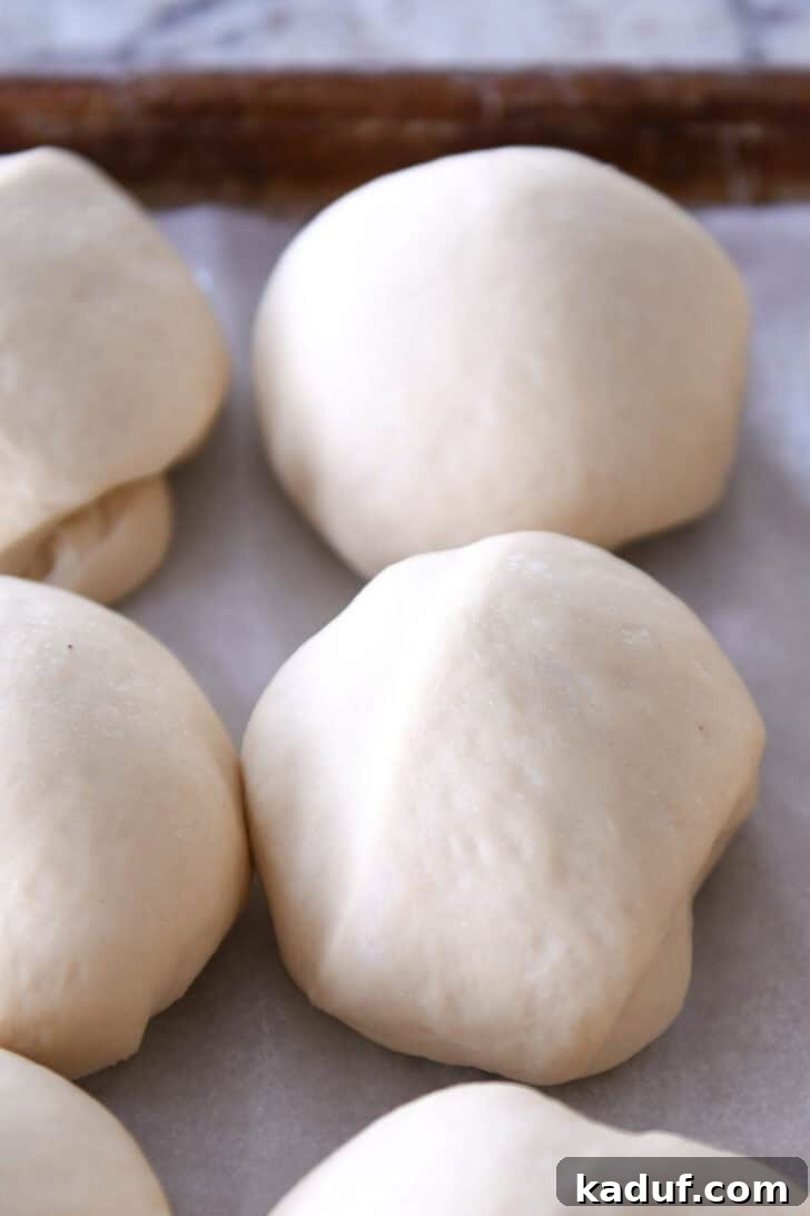 Delicious Homemade Flatbread 5 Raw dough balls on a piece of parchment paper.