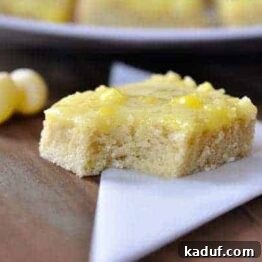 A delightful Lemon Drop Sugar Cookie Bar with a vibrant yellow glaze and candy pieces.