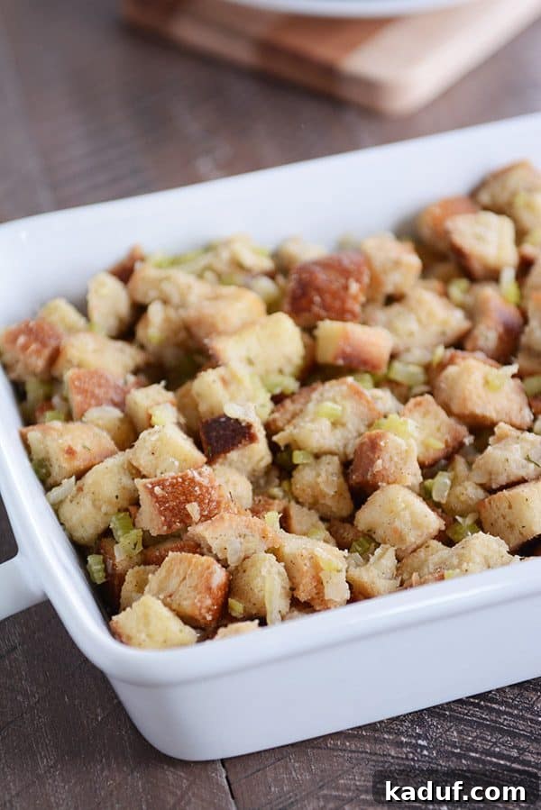 Classic Herb Thanksgiving Stuffing 2 White ceramic dish with stuffing, showcasing a golden-brown, inviting texture.