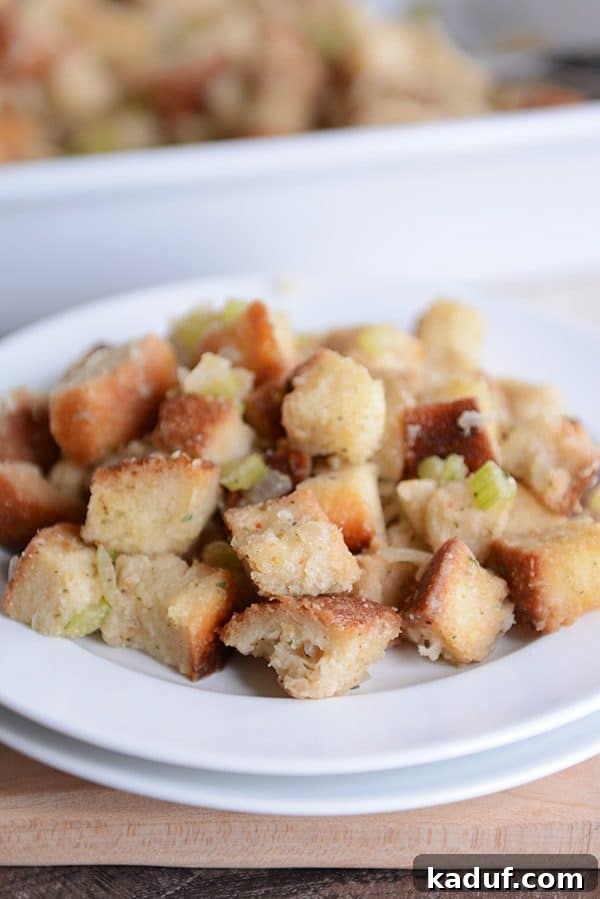 Classic Herb Thanksgiving Stuffing 3 A serving of Thanksgiving stuffing on a white plate, highlighting its comforting appearance.