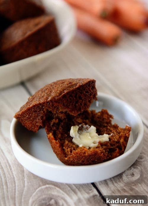 Morning Superfood Power Muffins 2 A golden brown muffin split in half with a pat of butter on the inside sitting in a small white ramekin, showcasing its wholesome texture and ingredients.