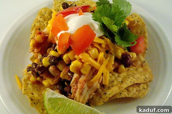 Slow Cooker Fiesta Chicken Bake 2 Tender chicken, corn, and black beans piled high over crispy tortilla chips, ready for toppings.