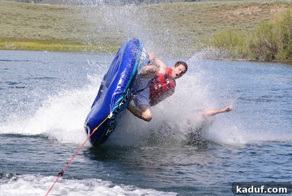 A man crashes dramatically into a lake after being flung from a tube, capturing an exhilarating moment of summer fun.