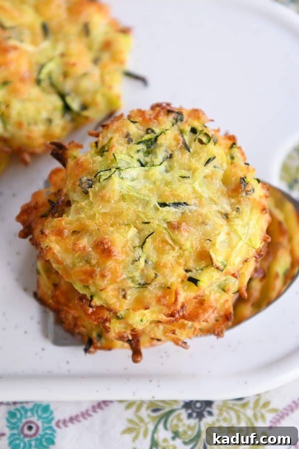 Cheesy Zucchini Gems 3 Top down view of a stack of baked cheesy zucchini bites.