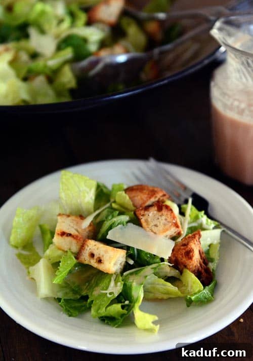 Gourmet Caesar Salad with Homemade Dressing 4 A white plate of caesar salad without dressing.