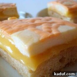 Sunshine Orange Cream Bars 4 Buttery shortbread bar topped with vibrant orange curd and a swirl of cream.