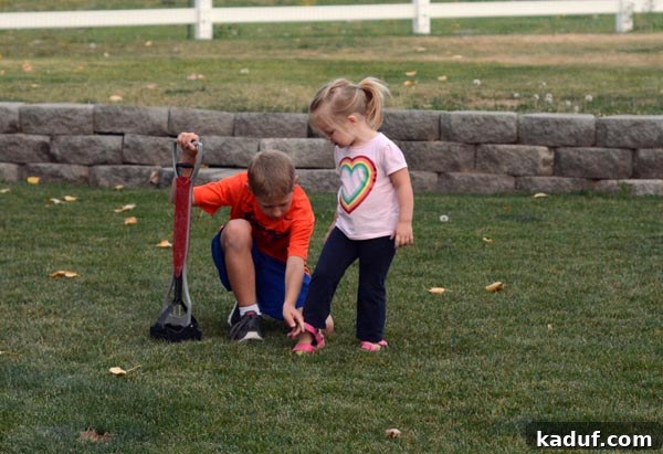A little boy helping his sister put her shoe on.