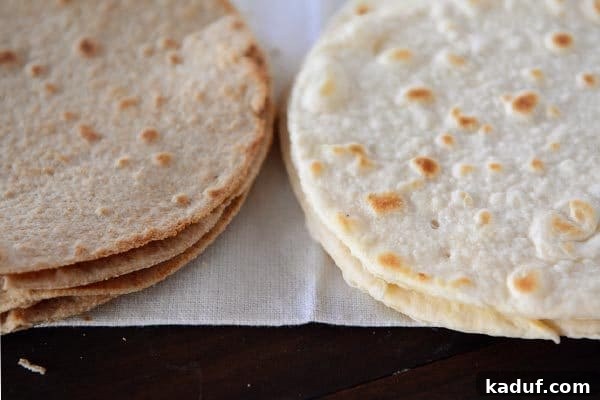 Step-by-Step Guide to Homemade White and Whole Wheat Tortillas 3 Two distinct stacks of homemade tortillas are displayed side-by-side, one pile of light, fluffy white flour tortillas and another of heartier, darker whole wheat tortillas.