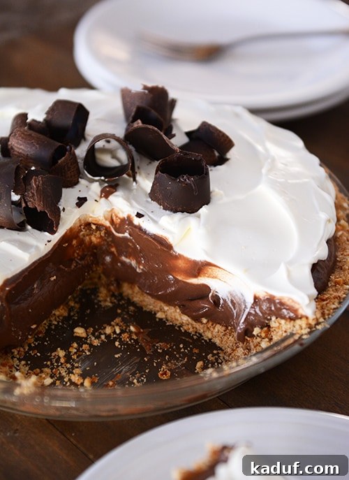 Salty Sweet Chocolate Pretzel Pie 2 A chocolate pudding pie with a slice taken out, revealing its delicious layers.
