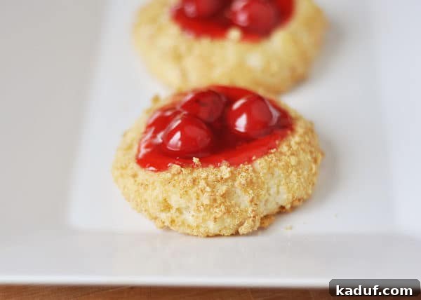 Velvet Cherry Cheesecake Cookies 3 Close-up of a Cherry Cheesecake Cookie, showing the crumb coating and the cherry filling in the center.