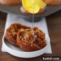 A whole grain honey bran muffin drizzled with honey, highlighting its moist interior.