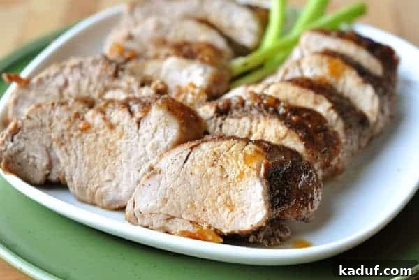 Spiced Brown Sugar Glazed Pork Loin 2 Thick, juicy slices of brown sugar spiced pork loin on a white plate, glistening with a rich glaze.