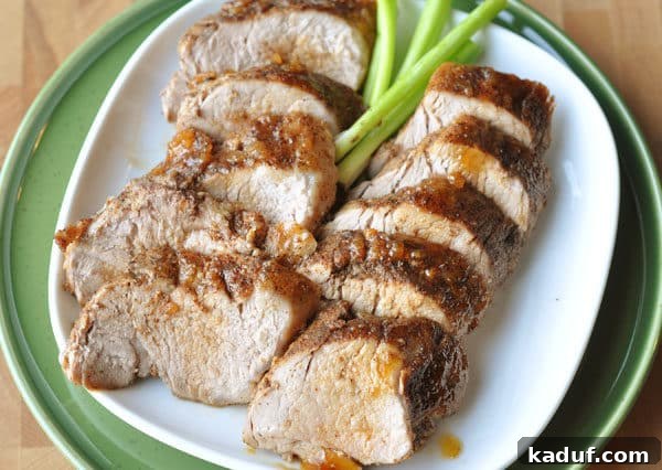 Spiced Brown Sugar Glazed Pork Loin 3 Top-down view of a white plate featuring thick slices of brown sugar spiced pork loin, elegantly arranged with a rich glaze.