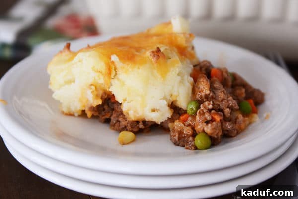 Lamb and Potato Comfort 11 A perfectly portioned serving of Shepherd's Pie sits on a stack of white plates, ready to be enjoyed.
