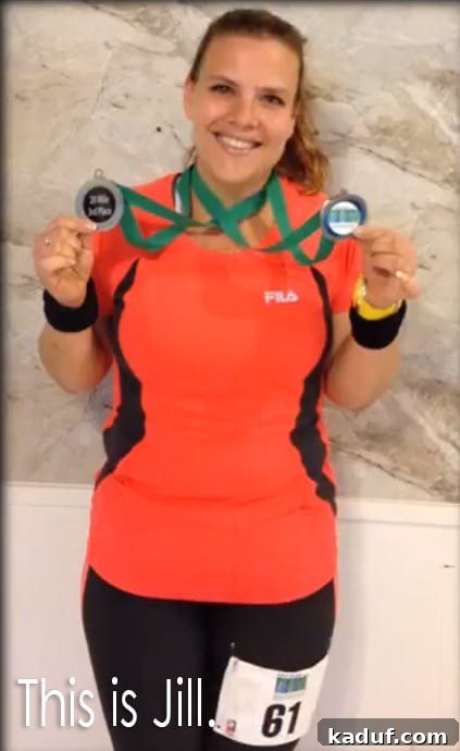 Unveiling Jill 2 A triumphant woman, Jill, stands smiling, proudly displaying two running medals draped around her neck. She represents a remarkable journey of fitness and perseverance.