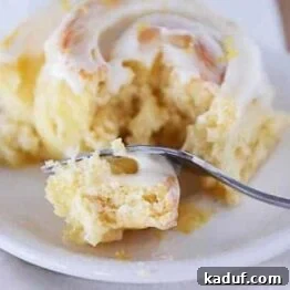 Lemon sticky buns with glaze and lemon zest in metal pan.