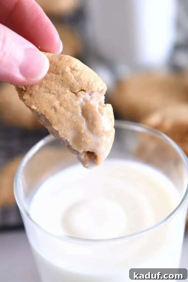 Irresistible Peanut Butter Cookies 10 Half of a delicious peanut butter cookie dipped in a glass of milk, highlighting its soft interior.