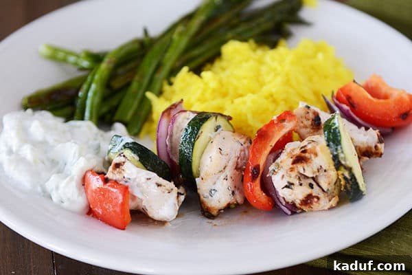 Juicy Greek Chicken Skewers with Refreshing Tzatziki 4 Grilled vegetables and veggies next to green beans and sauce.