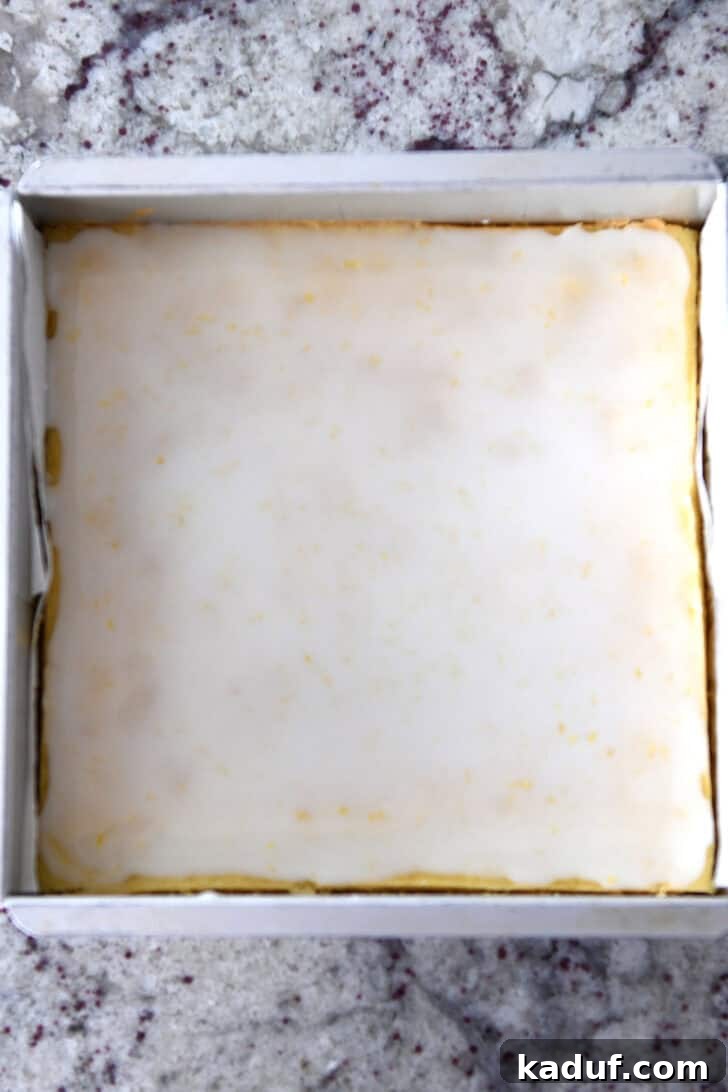 Mini Lemon Brownie Delights 6 Top down view of a metal pan filled with cooked and perfectly glazed lemon brownie batter, showing the smooth, set topping before cutting, ready for chilling.