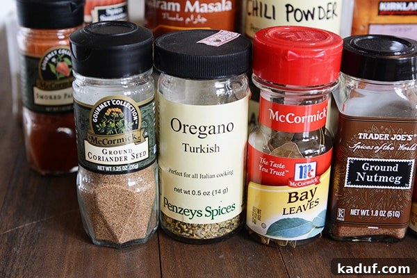 My Spice Cabinet Unveiled 7 A diverse selection of high-quality spices artfully arranged on a kitchen counter.