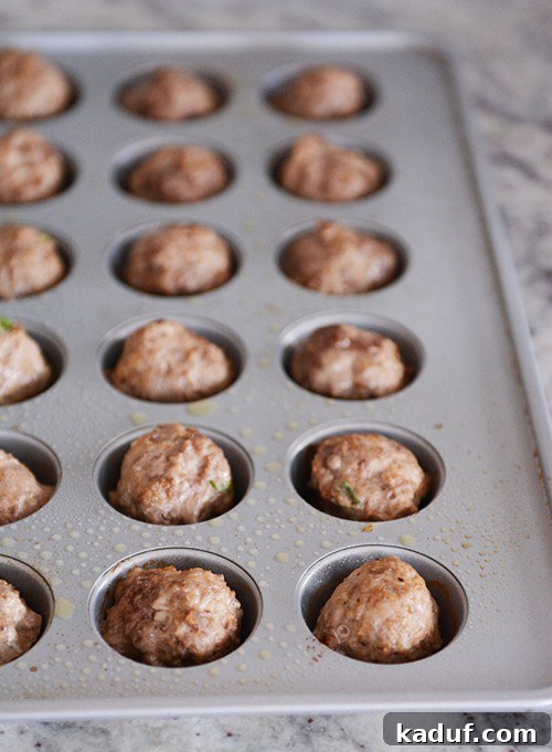 Sticky Zesty Orange Meatballs 4 Cooked meatballs in a mini muffin tin.