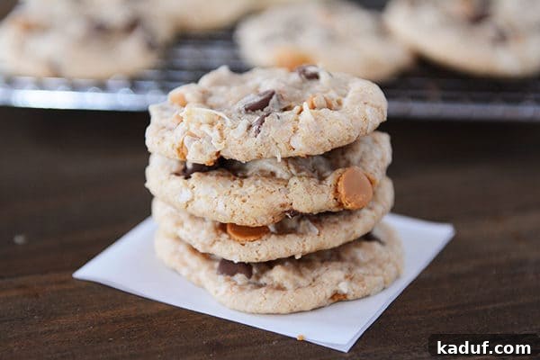 Soft Chewy Seven Layer Cookies Individual Perfection 5 A perfectly arranged stack of four golden-brown 7-layer cookies, highlighting their rich texture and generous distribution of mix-ins.