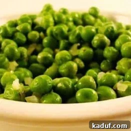 Buttery Peas with Thyme served in a decorative white bowl