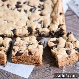 Slab of chocolate chip cookie bars cut into pieces, ready to be served from the pan.