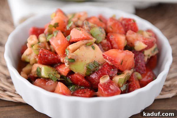 A white ramekin full of strawberry avocado salsa.