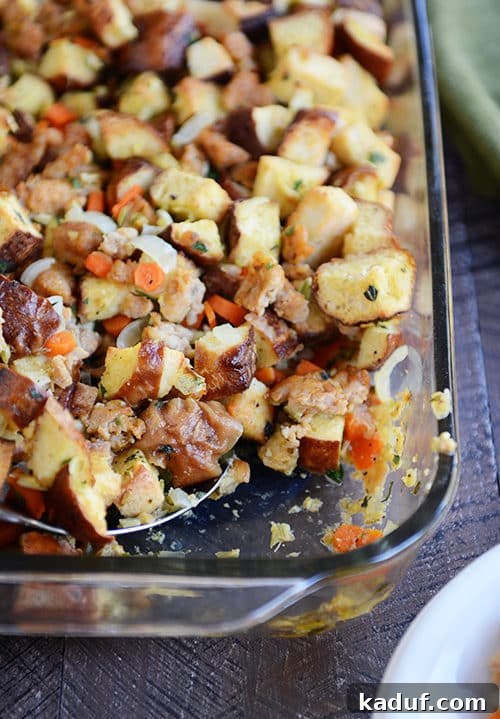 Pretzel and Sausage Stuffing Bake 2 Top view of a glass dish full of pretzel roll and sausage stuffing, golden brown and garnished.