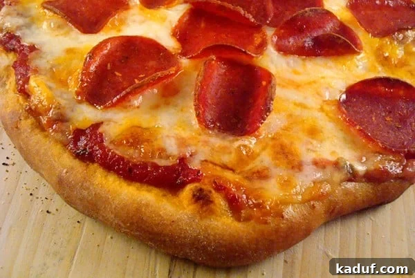 Craft Your Own Slice 3 Top view of a cooked pepperoni and cheese pizza, ready to be sliced.