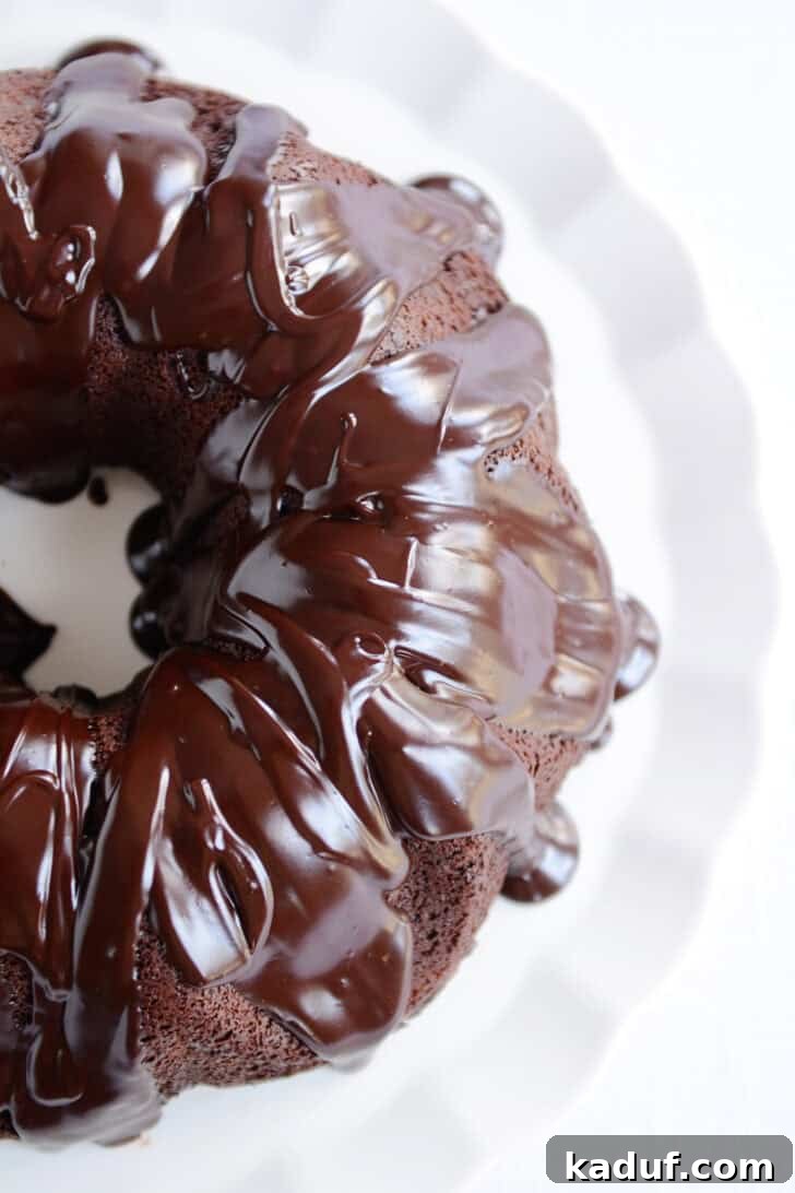Velvet Chocolate Fudge Bundt 2 A perfectly glazed chocolate bundt cake, viewed from above, glistening with rich chocolate ganache, ready to be served.