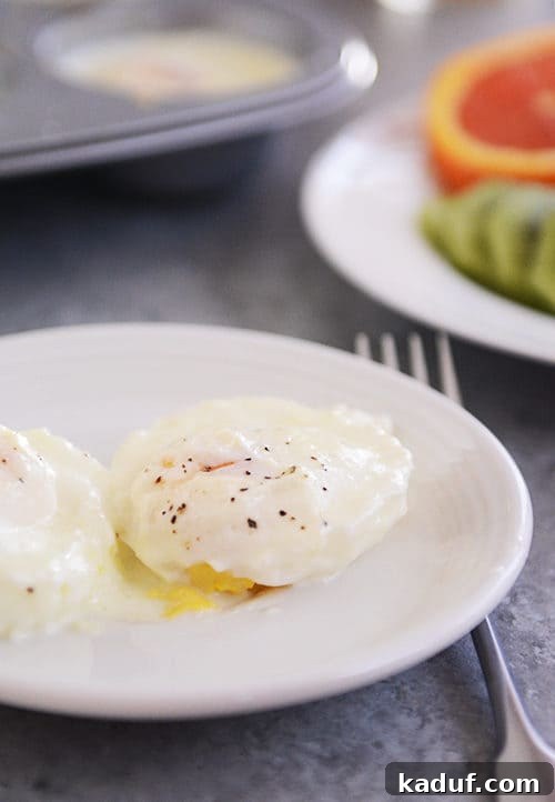 Christmas Baked Eggs and My Holiday Feast Plans 2 A beautifully presented white plate featuring a creamy, perfectly cooked baked egg, generously sprinkled with freshly ground black pepper, inviting you to indulge in a festive holiday breakfast.