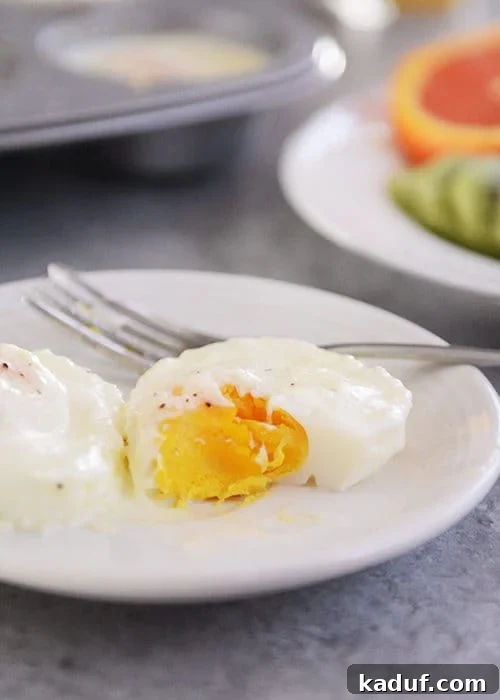 Christmas Baked Eggs and My Holiday Feast Plans 3 A close-up shot of a white plate holding a creamy, golden baked egg, with a small portion scooped out, revealing its rich texture and inviting warmth. Perfectly seasoned and ready to enjoy.
