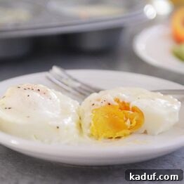 Christmas Baked Eggs and My Holiday Feast Plans 4 A close-up of a Christmas baked egg, perfectly golden and creamy, served on a white plate with a sprinkle of pepper.