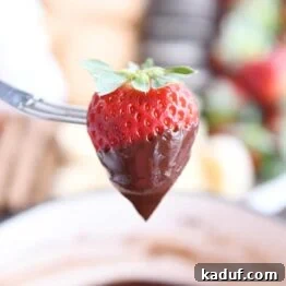 Decadent Chocolate Fondue 11 Chocolate dipped strawberry on fondue fork.