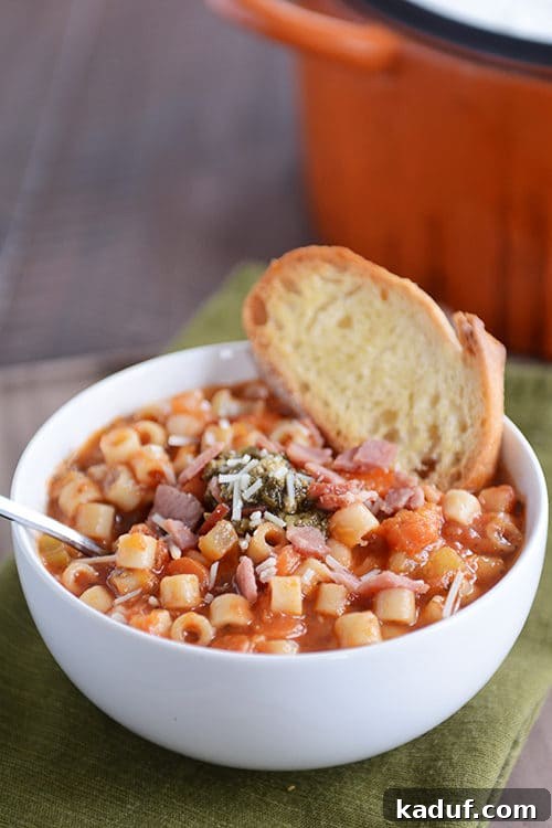 Heartwarming Winter Minestrone with Golden Garlic Bruschetta 2 A beautiful white bowl filled to the brim with vibrant winter minestrone soup, garnished with fresh herbs and a side of golden-brown garlic bruschetta, ready to be enjoyed.