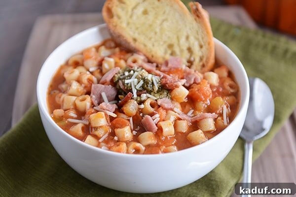 Heartwarming Winter Minestrone with Golden Garlic Bruschetta 3 A closer view of a white bowl of hearty minestrone soup, showcasing the vibrant vegetables, pasta, and rich broth, accompanied by a golden piece of garlic bread.