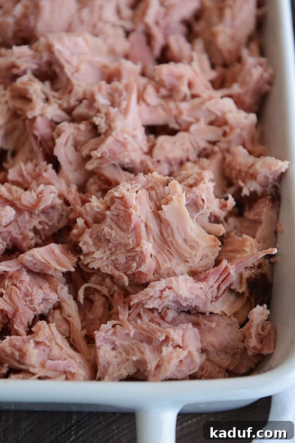 Instant Pot Sweet Glazed Ham 4 A white dish full of shredded, baked ham.