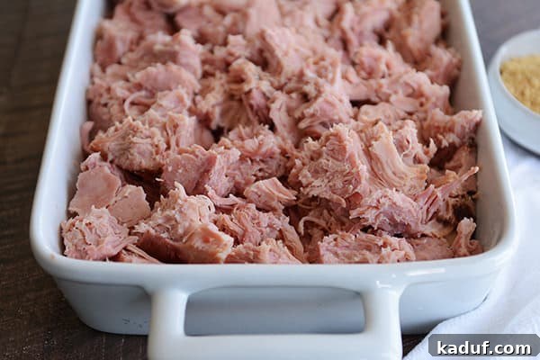 Instant Pot Sweet Glazed Ham 5 A white dish full of shredded, baked ham.