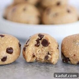 Three no-bake cookie dough bites lined up, the middle one having a bite taken out.