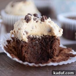 A delicious chocolate cupcake with a thick layer of frosting on top, showcasing the rich texture.