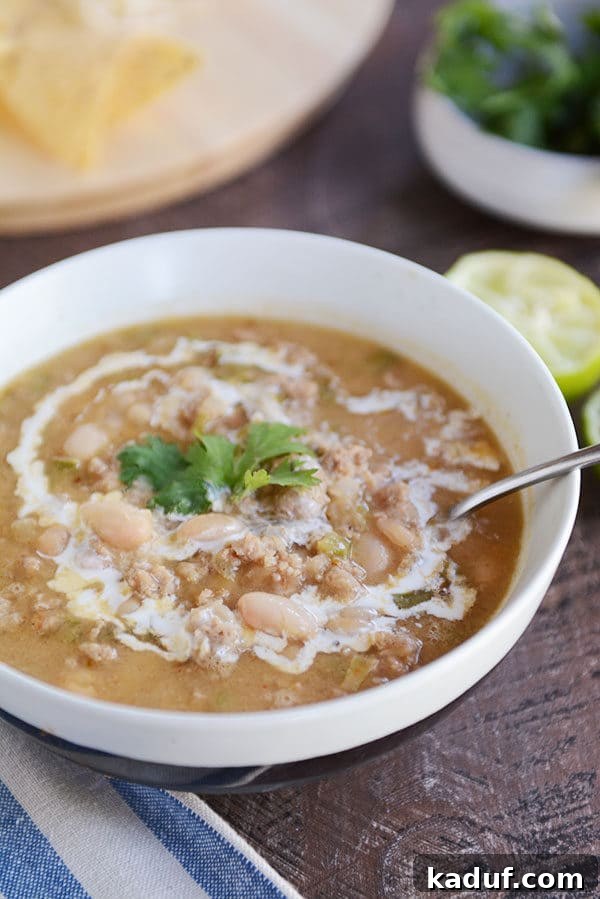 Deep Roasted Garlic White Bean Chili 5 White bowl of white bean chili topped with parsley sprigs.
