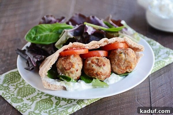 Hearty Greek Meatball Pockets with Quick Tzatziki 3 A meatball and veggie stuffed Greek pita next to a pile of lettuce.