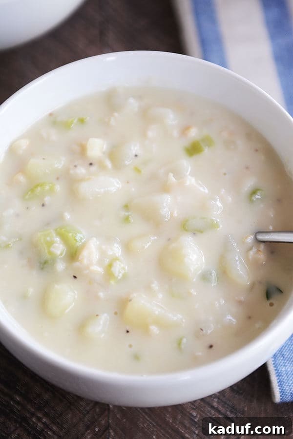 Our Signature New England Clam Chowder 3 Top view of a generously filled bowl of creamy New England clam chowder, rich with vegetables and clams.