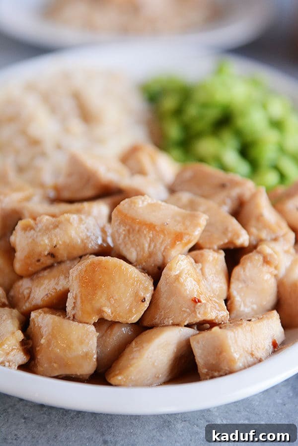 Effortless 20-Minute Skillet Honey Garlic Chicken 4 Close-up of glazed golden brown chicken cubes on a white plate, showcasing the rich sauce.