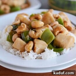 Close-up of a bowl of Chinese Cashew Chicken with cashews, bell peppers, and sauce.